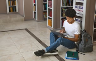 Young Black male student seated in library iStock-1173560703-2